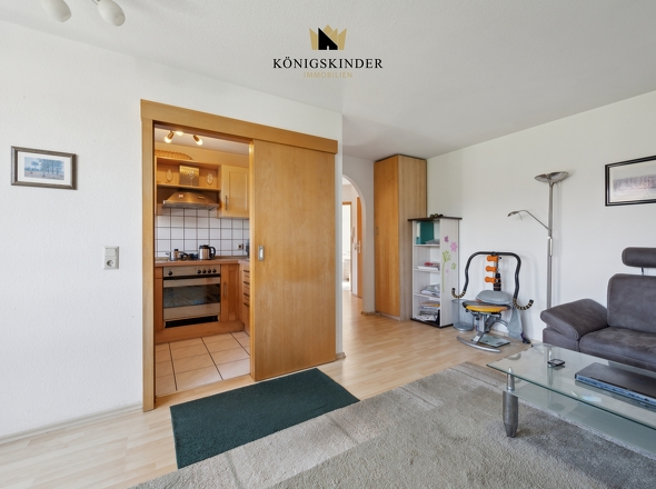 Eine raumsparende Schiebetür verbindet Wohn-Essbereich und Küche. 