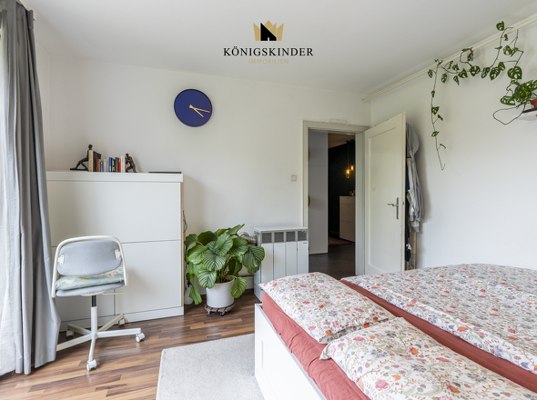 Helles Schlafzimmer mit großem Fenster und freundlichem Raumgefühl