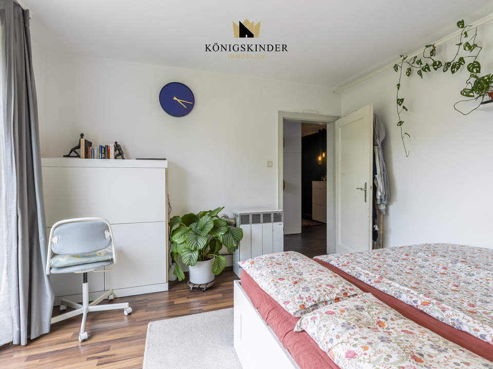Helles Schlafzimmer mit großem Fenster und freundlichem Raumgefühl
