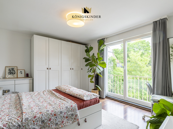 Helles Schlafzimmer mit großem Fenster und freundlichem Raumgefühl